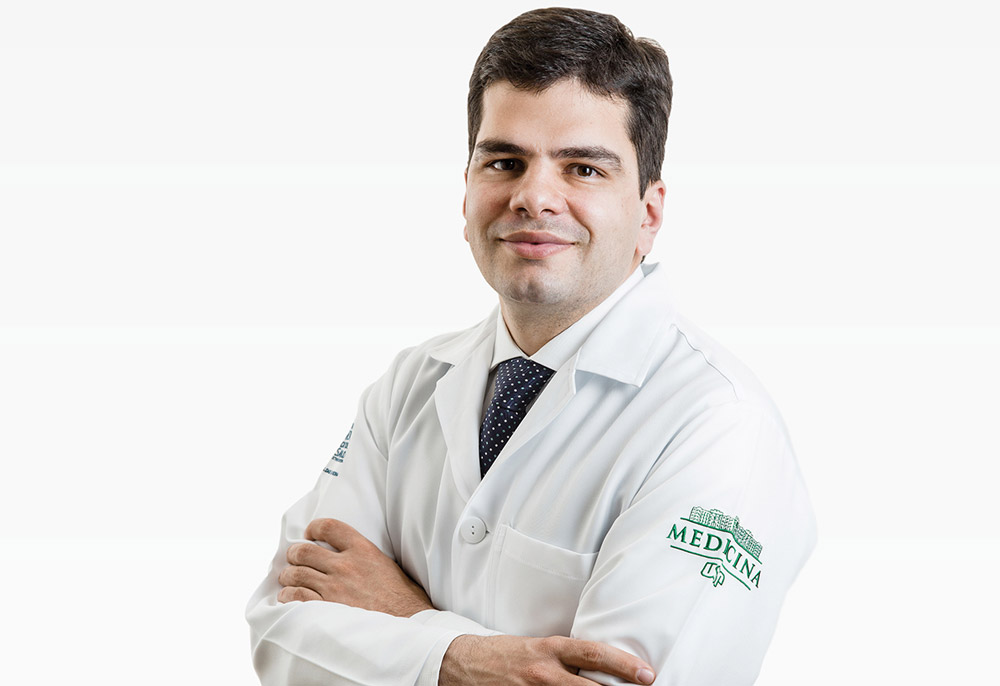 Dr. Paulo Afonso de Carvalho, urologista, de jaleco branco com os braços cruzados